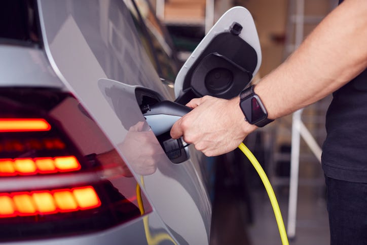Stock photo of a man using a home charging station. 
