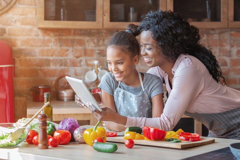 mother and daughter take online cooking class