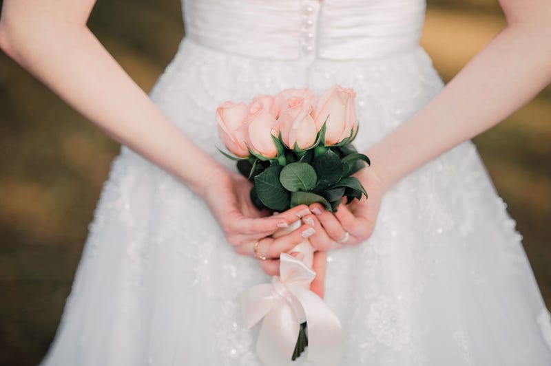 Bride with flowers behind her back