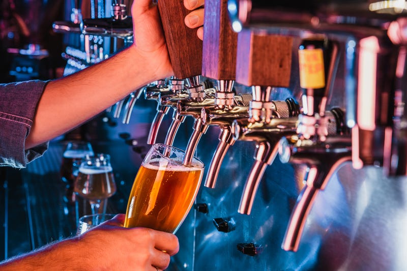 person pouring beer from tap