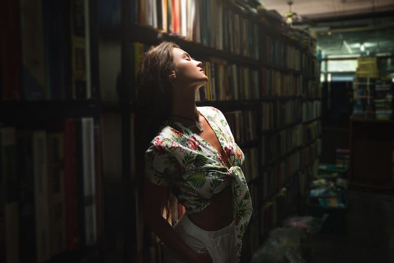 Beautiful woman poses in bookstore