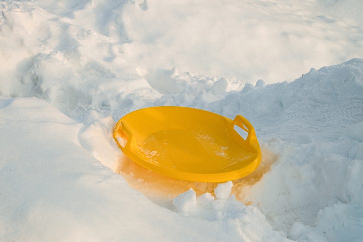 a yellow sled in the snow