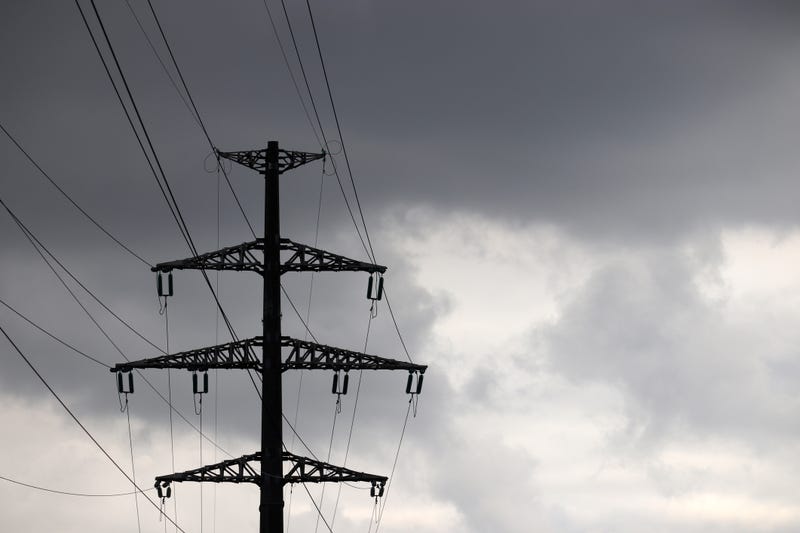 High voltage tower silhouette with electrical wires on storm sky background with dark clouds - stock photo