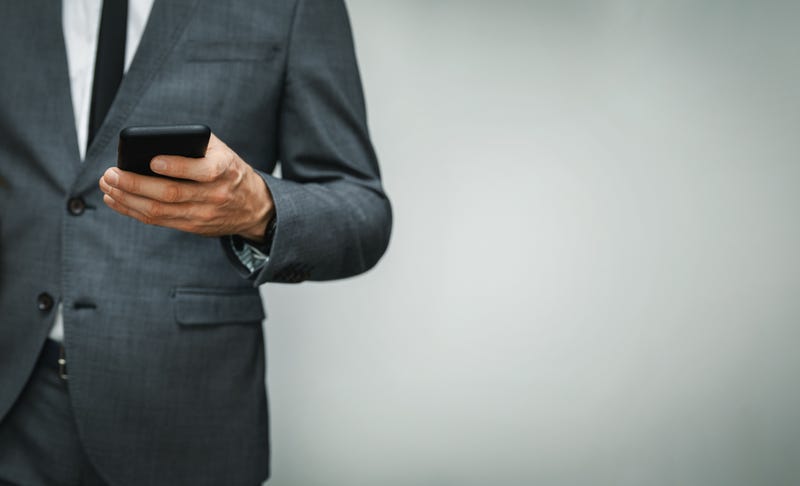 man in suit texting
