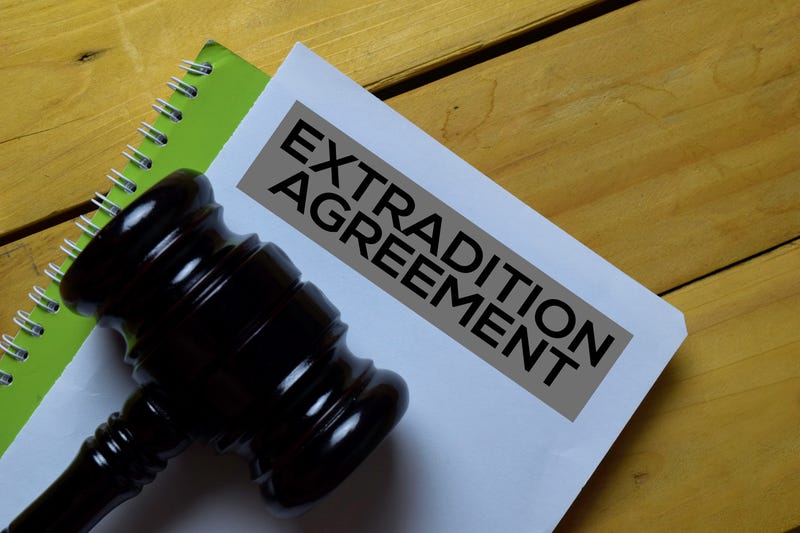 Extradition Agreement Document form and Black Judges gavel on wooden desk. Law concept