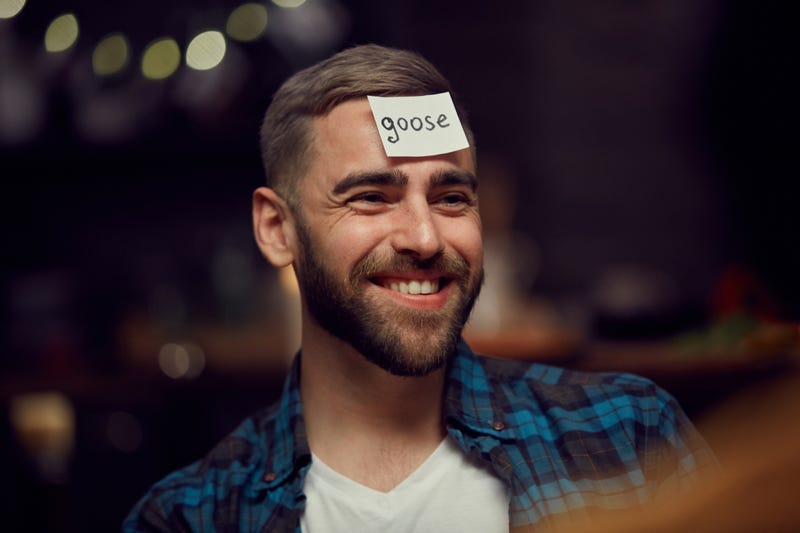A man with a card on his forehead reading Goose