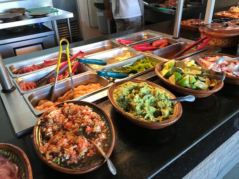 Mexican food on display in a buffet line
