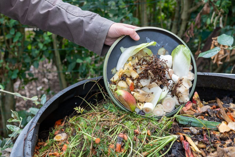 Woman throwing compost with kitchen waste