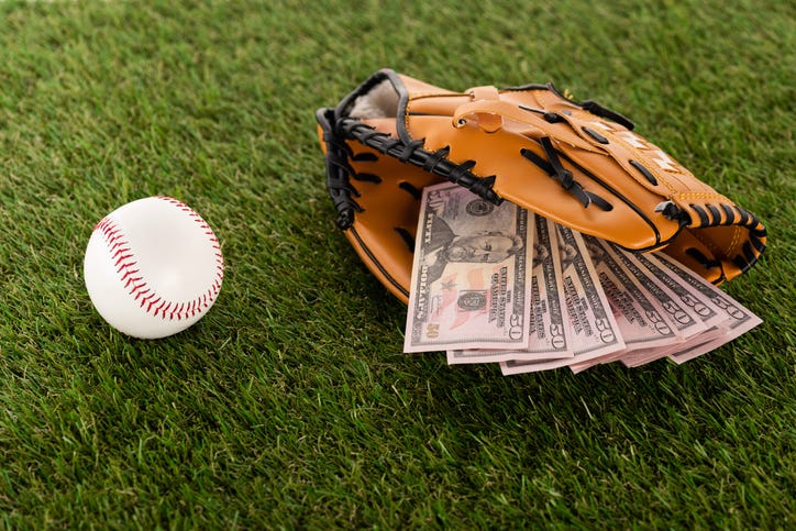 Money in a baseball glove depicting sports gambling.