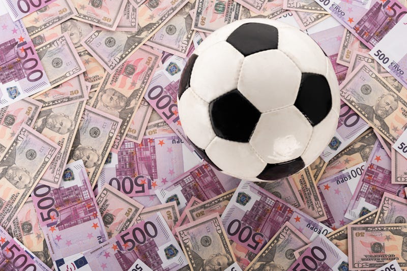 soccer ball on euro and dollar banknotes