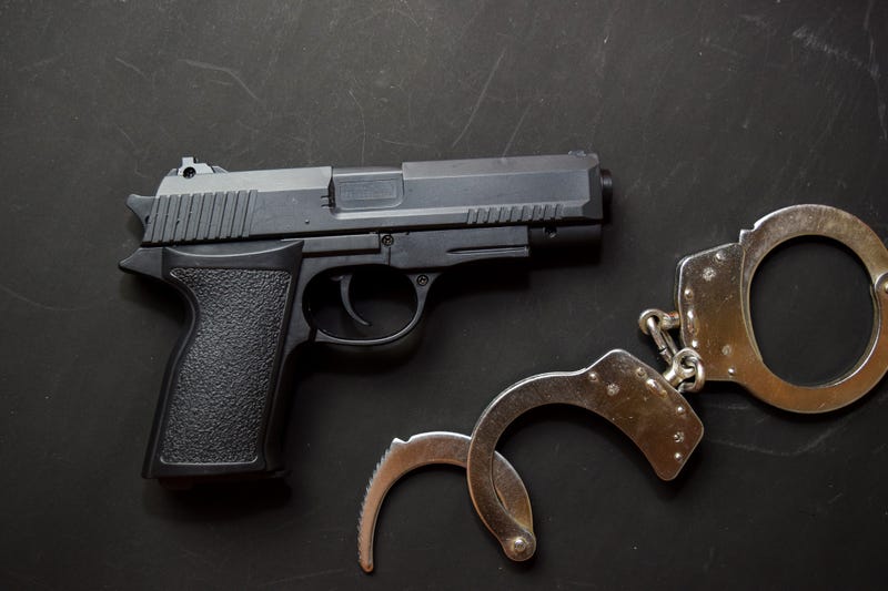 Handcuffs and Gun isolated on black background. Justice and law concept