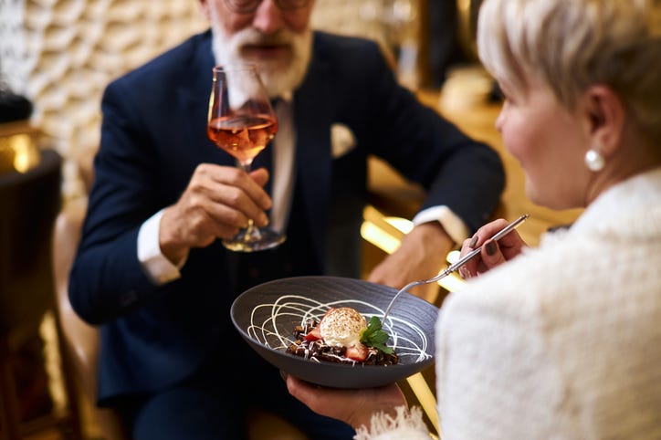 Older rich couple enjoying an expensive meal.