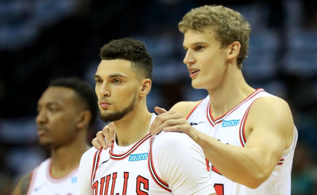Lauri Markkanen helps to warm up teammate Zach Lavine prior to a game.