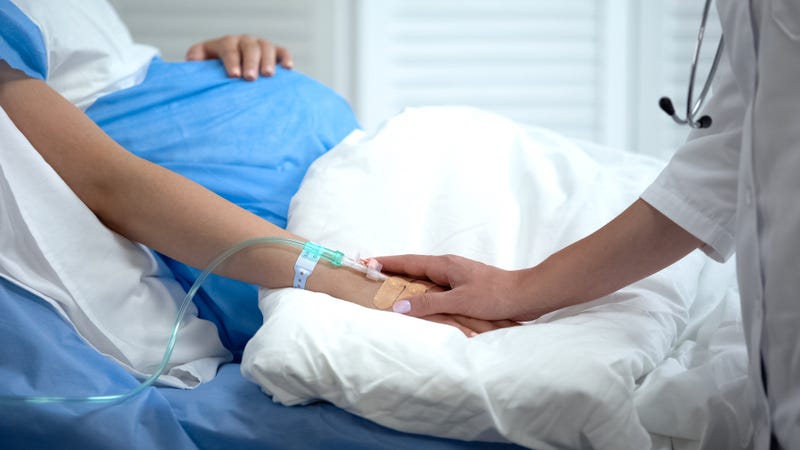 Doctor holding pregnant woman hand