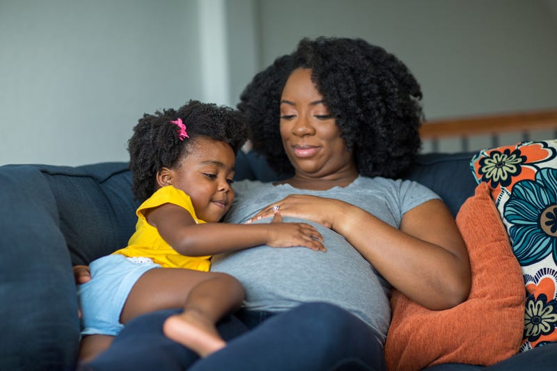 A pregnant woman and a child.