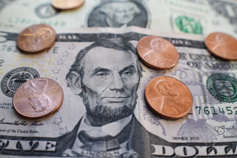 A five dollar bill, a one dollar bill, and six pennies.