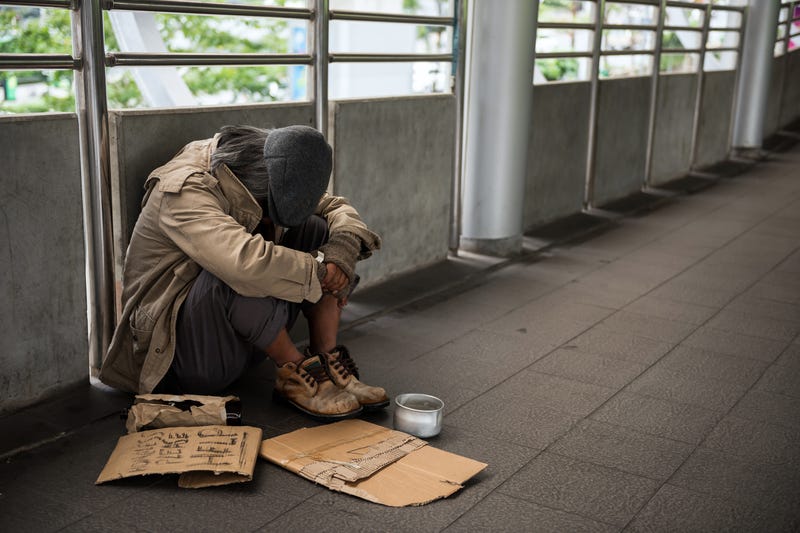 Homeless man in city with sign