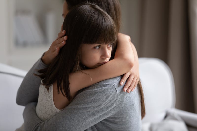 stock image of a little girl hugging her mother
