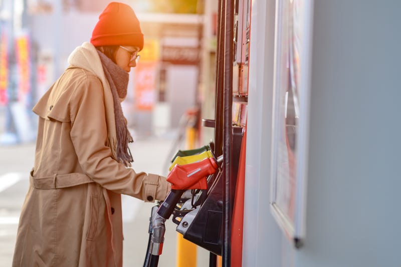 gas pump nozzle in gas station in socket ready to fill up by self service of woman traveller