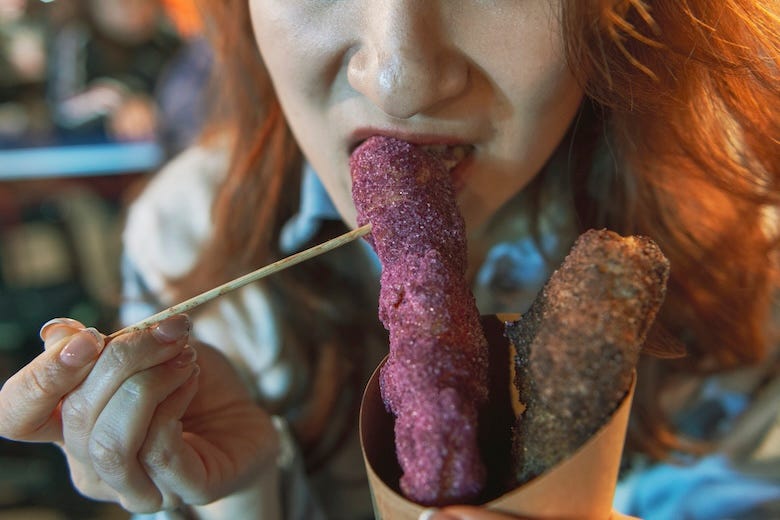 Woman eating purple street food