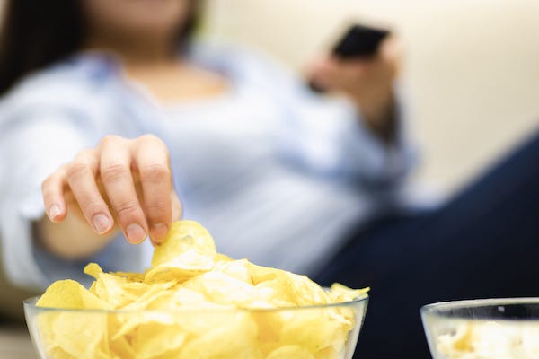 Woman eating a bowl of potato chips
