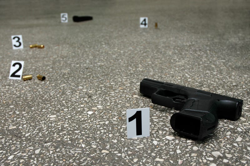 Guns and bullets on the floor with evidence markers.