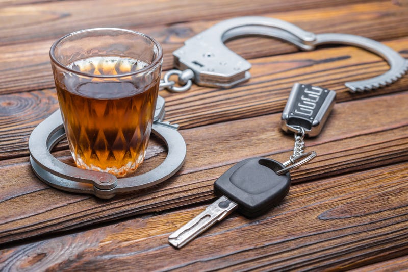 Handcuffs around a drink with keys