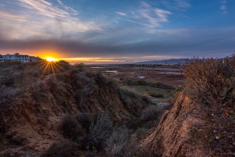 Long exposure bluff top view of Ballona Wetlands at sunset with colorful sky and Santa Monica Mountains in the distance, Playa Del Rey, California