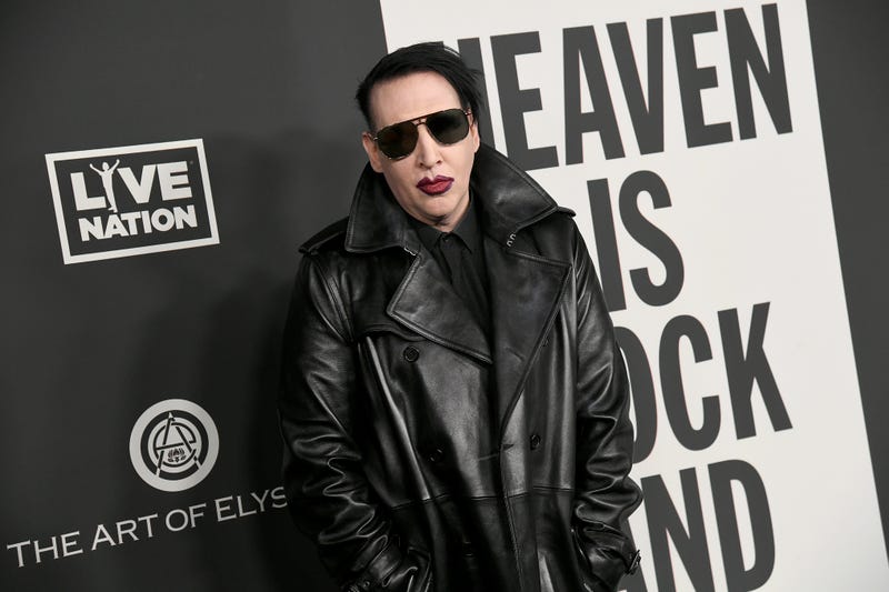 marilyn manson wearing sunglasses before black and white blackdrop