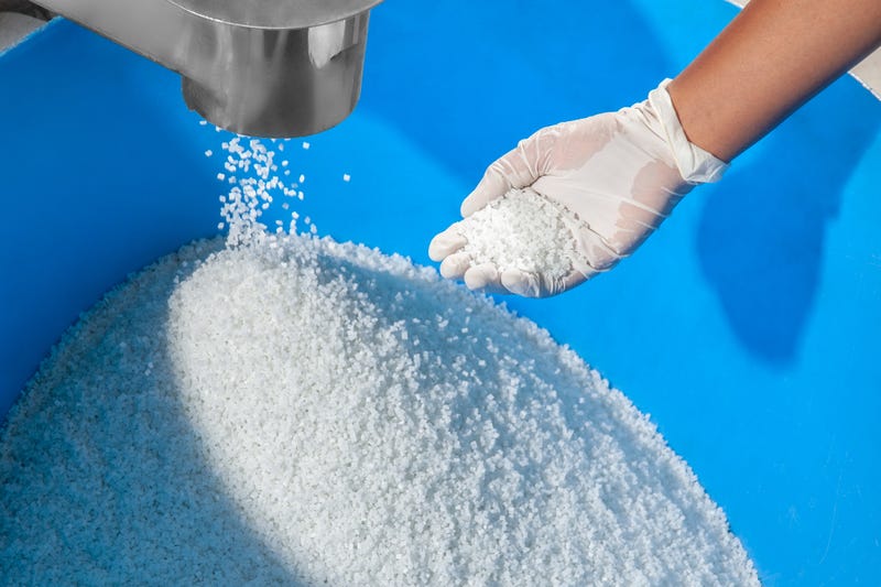 FINAL MANUFACTURED WHITE POLYMER GRANULES BEING ACCUMULATED IN BLUE PIT,