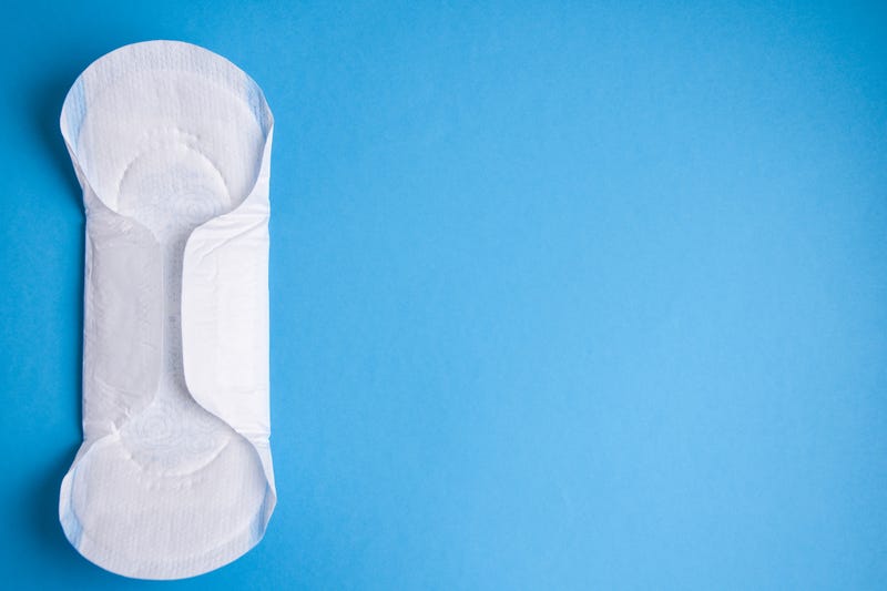 Period pad on blue background stock photo.