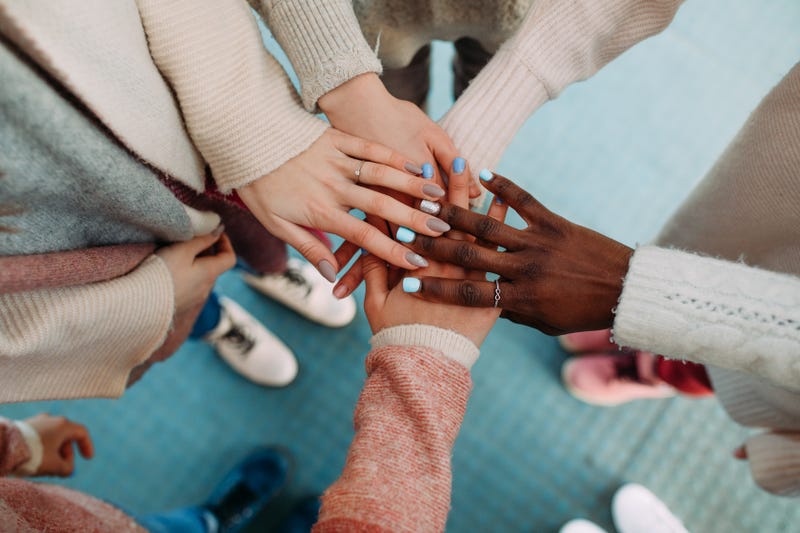 Women putting hands together