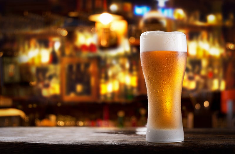close up of cold glass of beer in a bar on a wooden table
