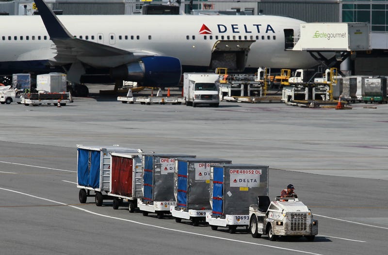 A Delta Airlines baggage cart drives by a Delta Airlines plane at San Francisco International Airport on July 27, 2011 in San Francisco, California.
