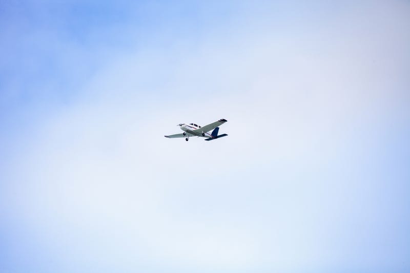 A small Cessna 172 plane soars through the blue sky over the southwestern part of Florida.