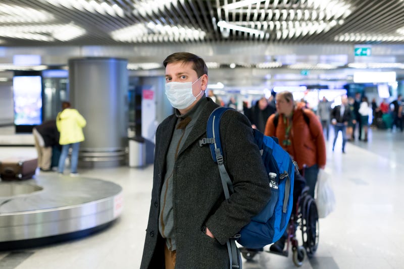 A man wearing a medical face mask in an airport