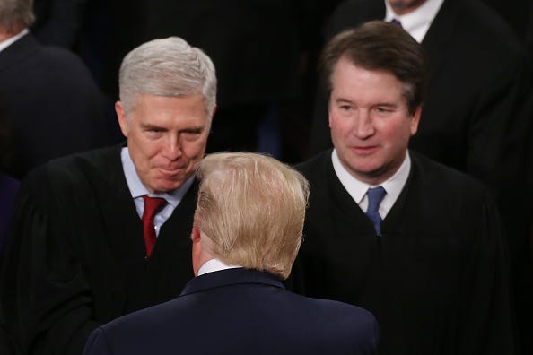 U.S. President Donald Trump greets Supreme Court Justice Neil Gorsuch as Supreme Justice Brett Kavanaugh looks on ahead of the State of the Union address in the chamber of the U.S. House of Representatives on February 04, 2020 in Washington, DC. 