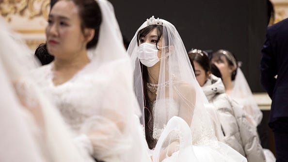 Bride and Groom Kiss Through Surgical Masks Amid Coronavirus Outbreak