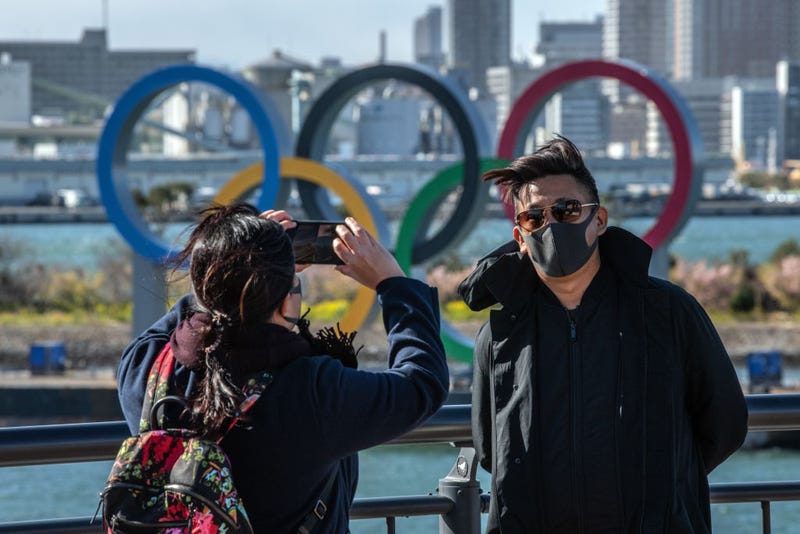 A man wearing a face mask has his photograph taken in front of the Olympic Rings in Odaiba on March 5, 2020 in Tokyo, Japan. 