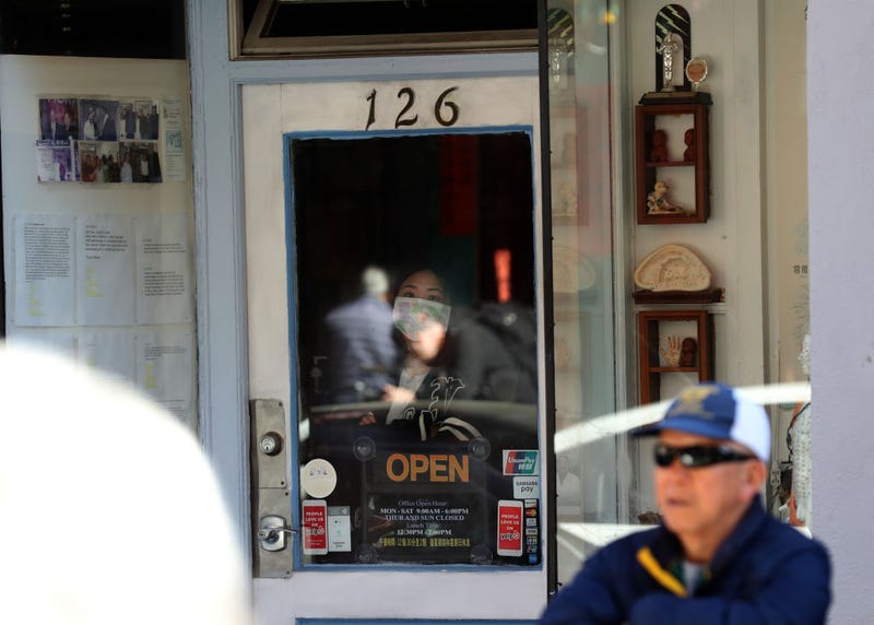 A woman wears a surgical mask as she looks out of a window as U.S. Speaker of the House Rep. Nancy Pelosi (D-CA) tours San Francisco's Chinatown on February 24, 2020 in San Francisco, California.