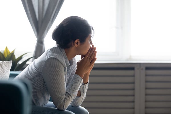 Pensive woman staring out window