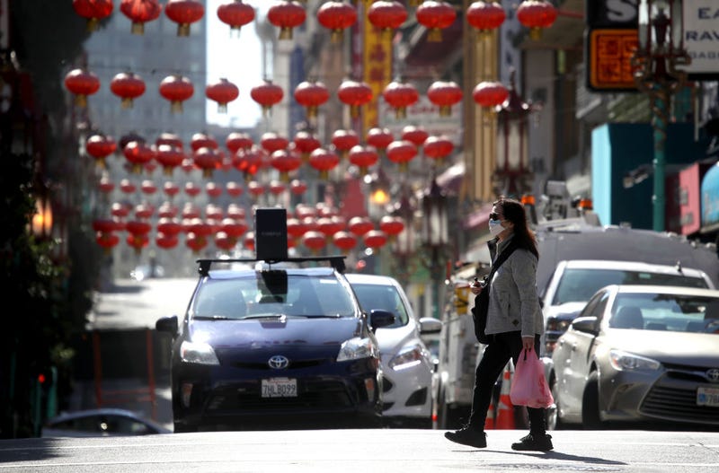 People wear surgical masks as they walk along Chinatown's Grant Avenue on February 26, 2020 in San Francisco,