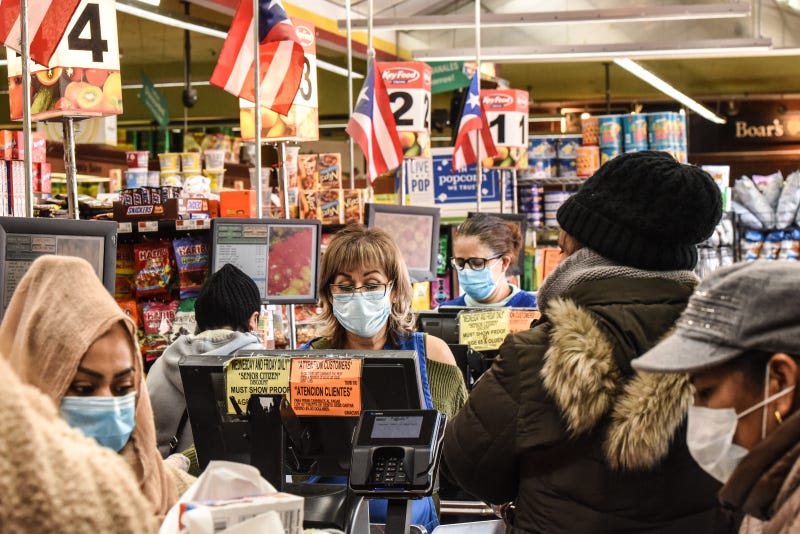 Cashiers and customers wear masks in a grocery store in Bushwick, Brooklyn