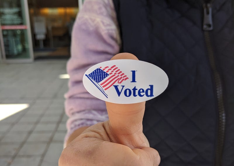 person taking a selfie of thumbs up with I voted sticker