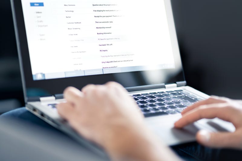 Email inbox full of messages and text. Man reading electronic mail with laptop. Spam, junk and e marketing on screen. Looking and checking received posts. - stock photo