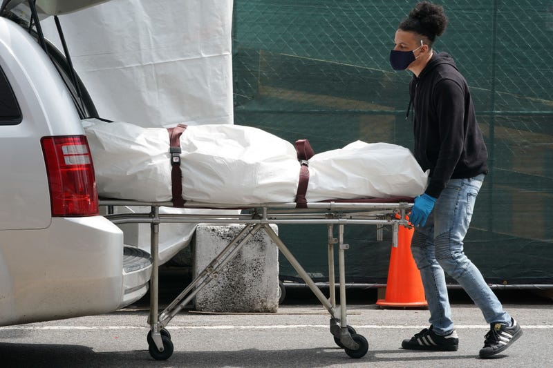 A body is moved from a refrigeration truck serving as a temporary morgue to a vehicle at the Brooklyn Hospital Center, in the Borough of Brooklyn on April 8, 2020 in New York.