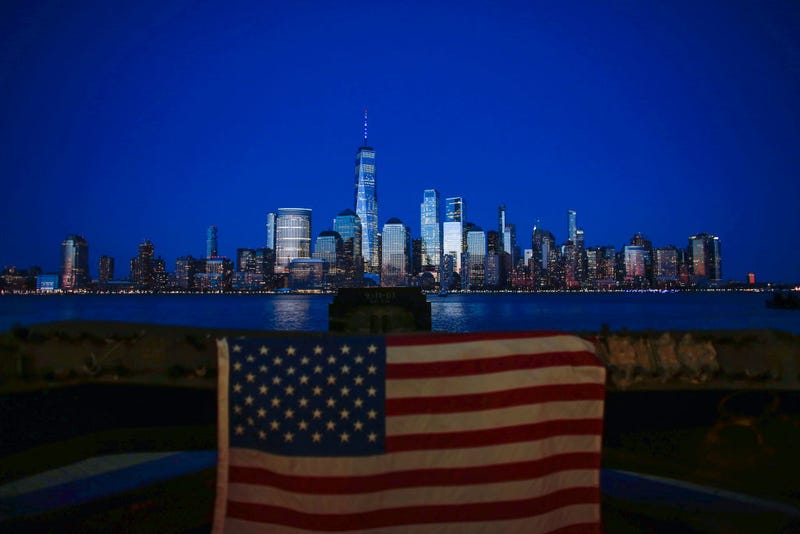 One World Trade Center is lit in blue on April 9, 2020 as seen from Jersey City, New Jersey. Landmarks and buildings across the nation are displayed blue lights at the time to show support for health care workers and first responders on the front lines against the coronavirus pandemic.