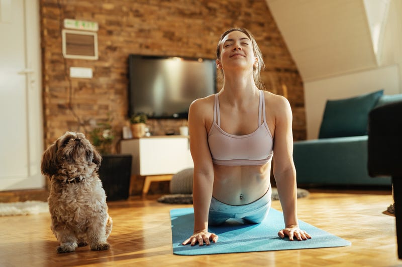 woman and dog doing yoga