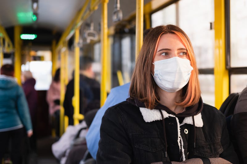Woman with mask on bus stock photo. 