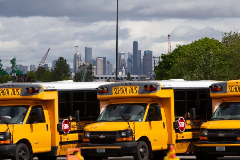 School buses sit idle in a bus yard.